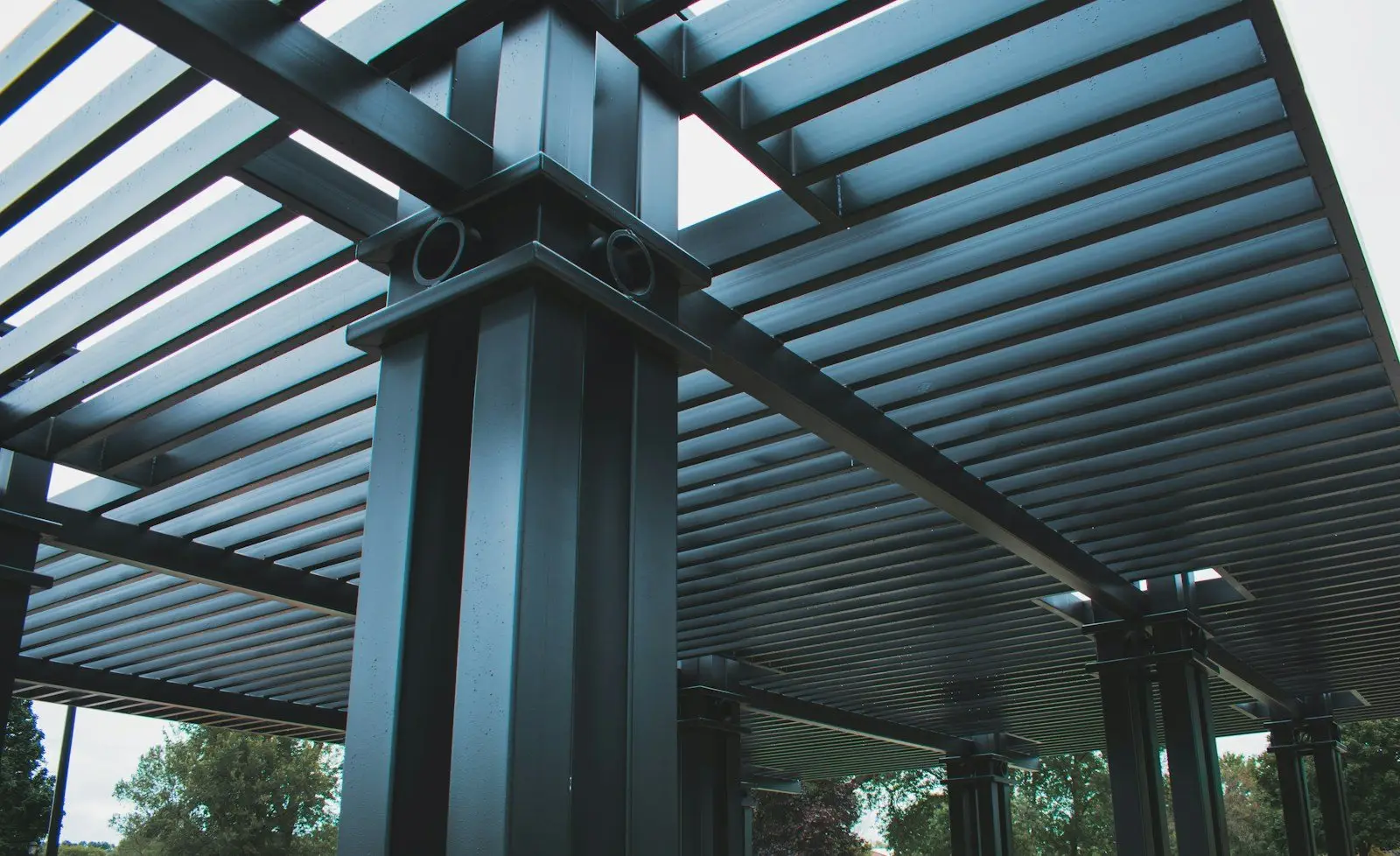 Dark louvred aluminium pergola on square columns, seen from below
