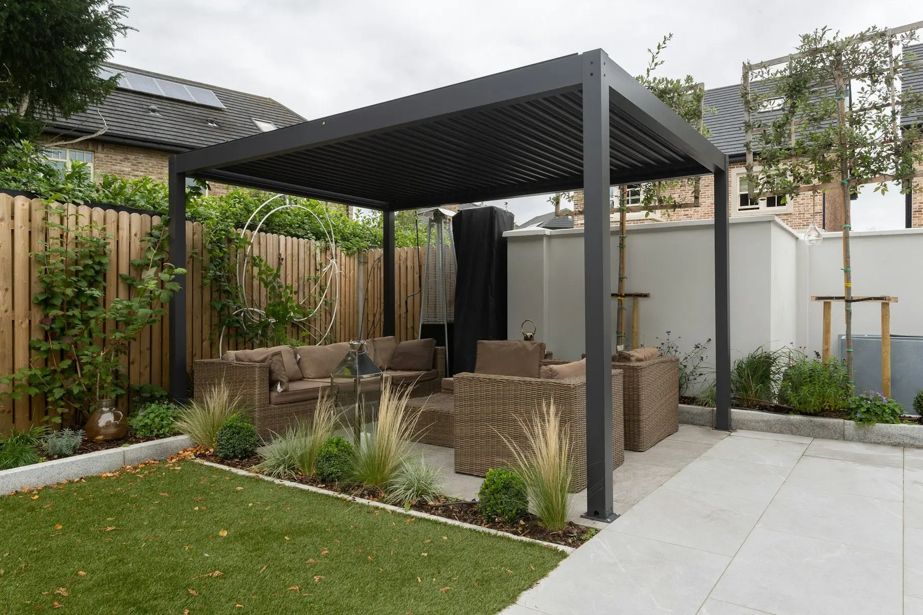 Charcoal aluminium pergola over a garden lounge