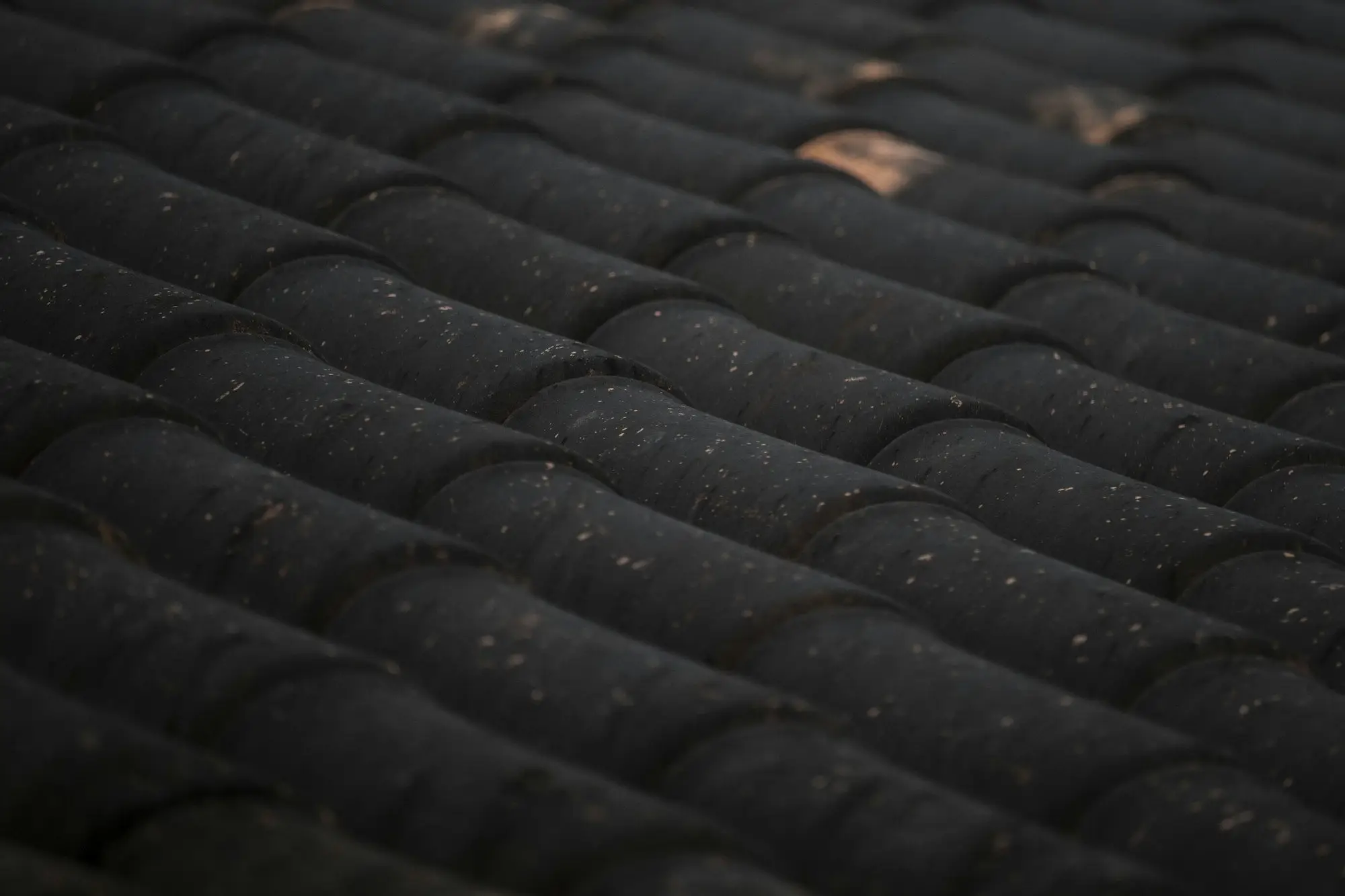 Close view of dark stone coated roof tiles with a granular matte finish